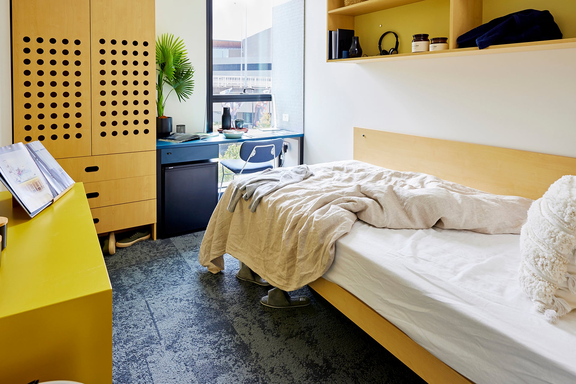 Desk and white single bed in front of window in Scape bedroom.